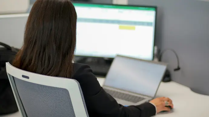 a woman sitting in front of a laptop computer